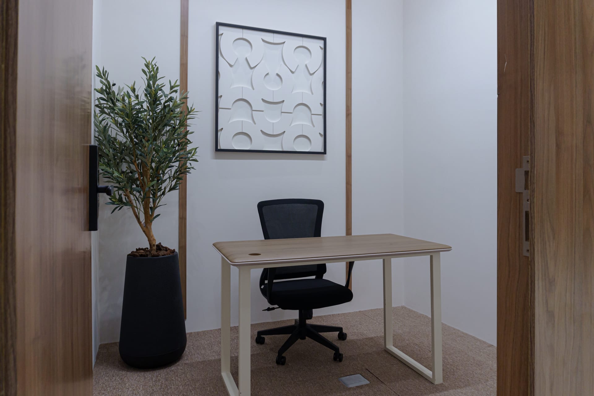 Inside a Tasees private office with desk, chair, and branded artwork